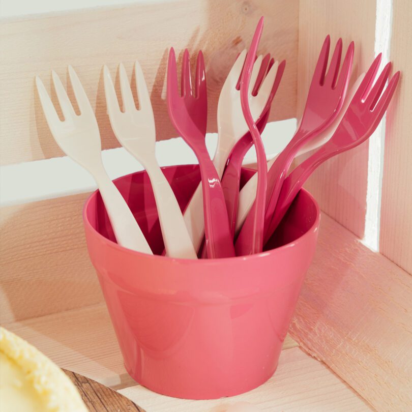 Small white and pink forks in cutlery pot