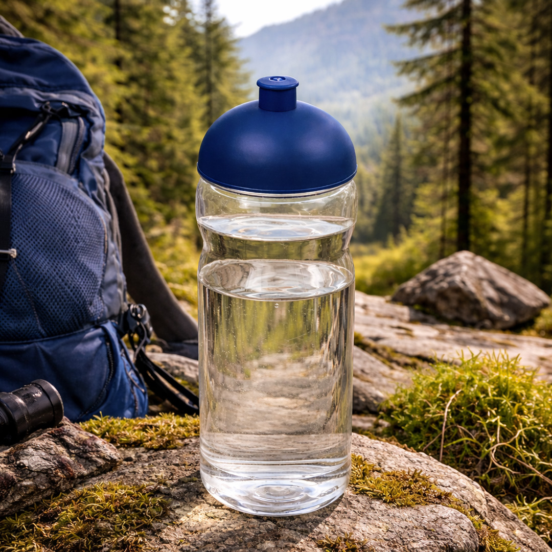 blue water bottle with pull out lid in hiking setting
