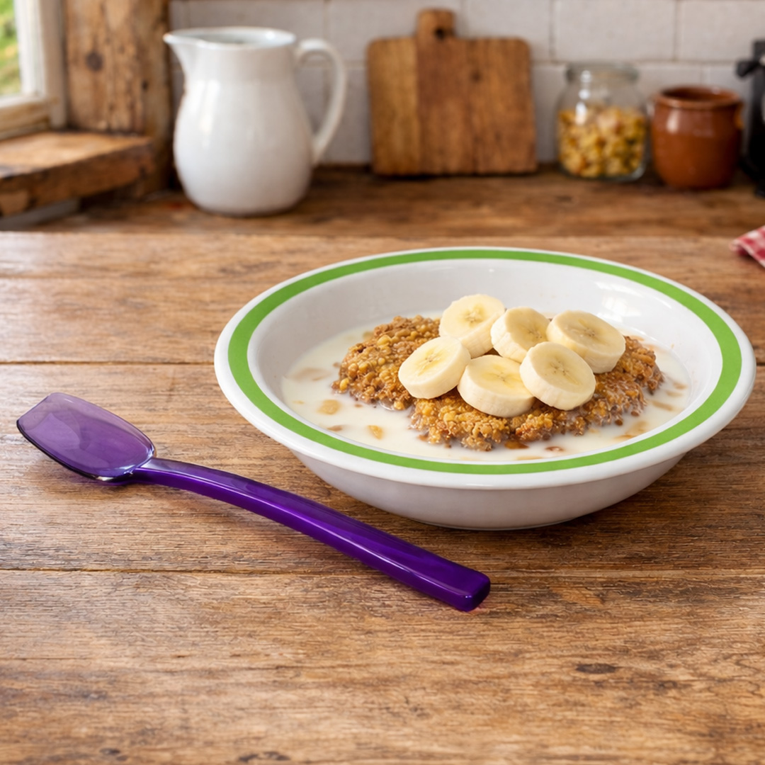 Purple narrow flat edge spoon in kitchen with cereal and fruit in bowl