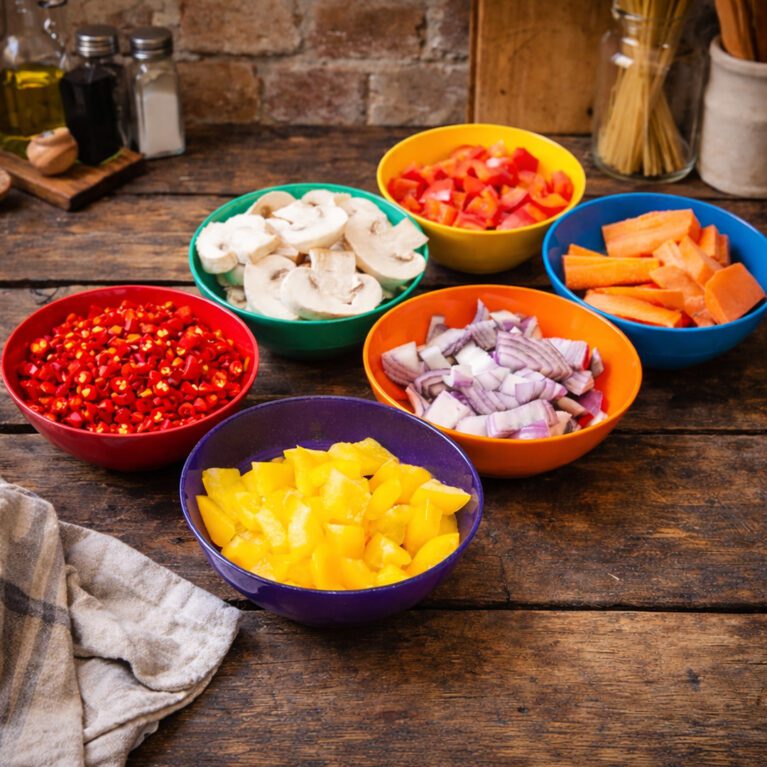6 bowls with chopped vegetables in a kitchen setting