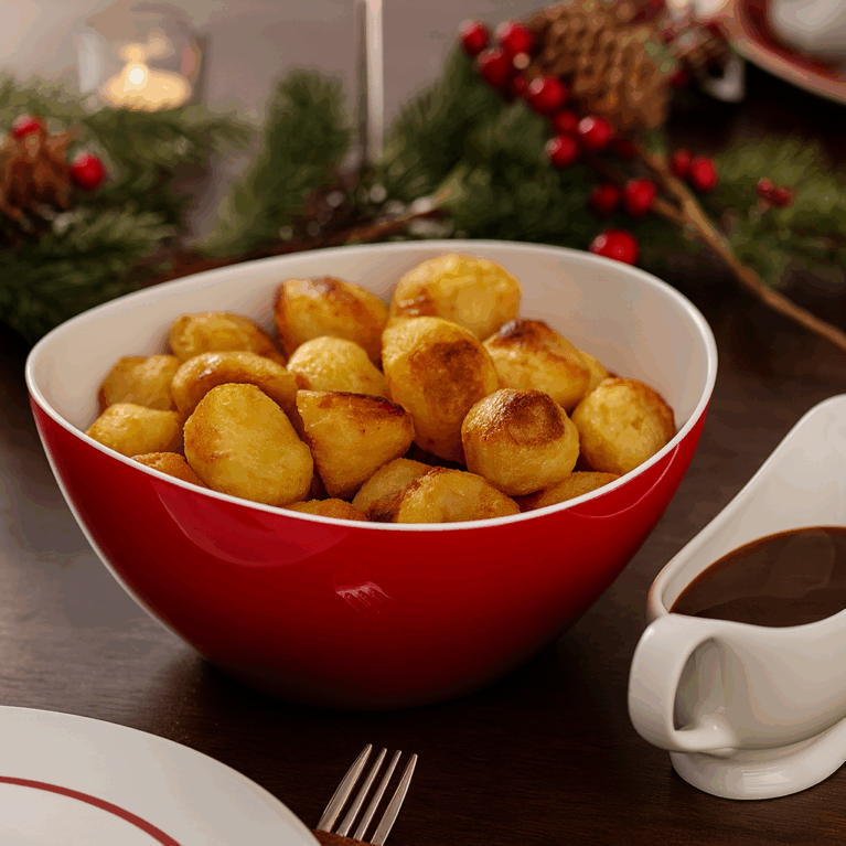 Large Red Curved Serving Bowl with Roast Potatoes in Christmas Setting