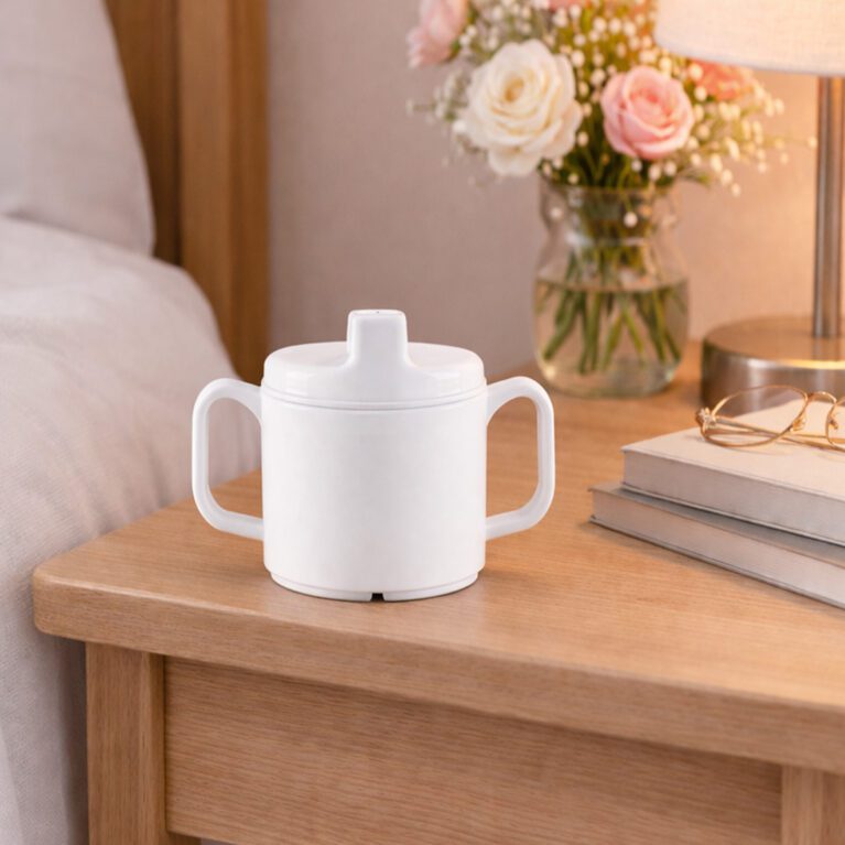 White 2 handled cup with Sippy lid next to bed