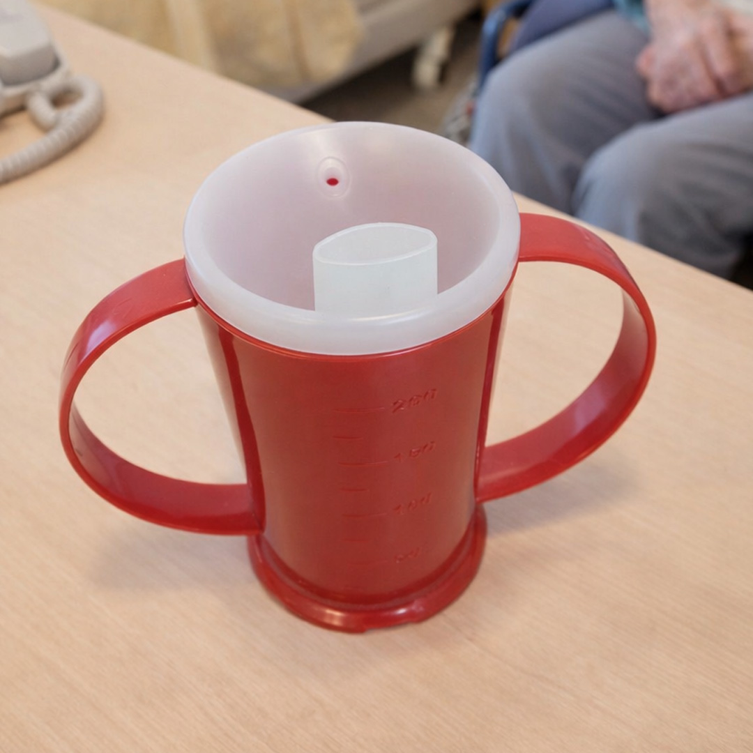 Red 2 handled beaker with wide spout in care home