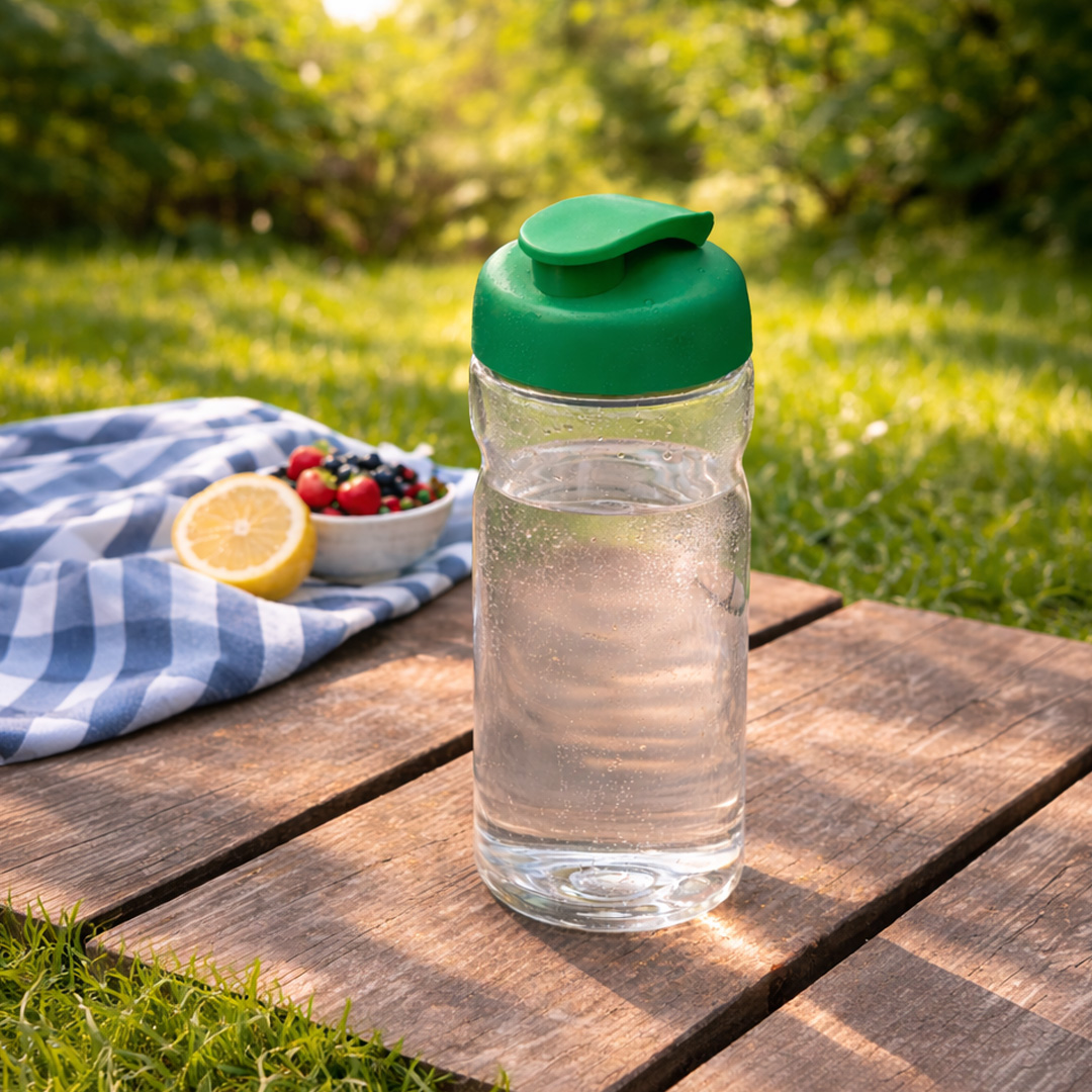 green water bottle with fip lid in garden setting
