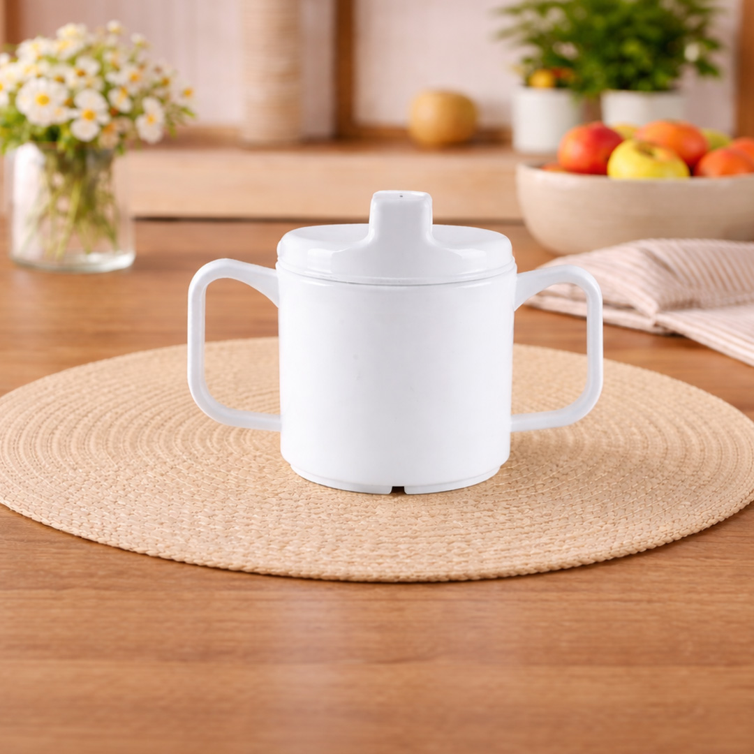 White 2 handled cup with Sippy lid on table with flowers